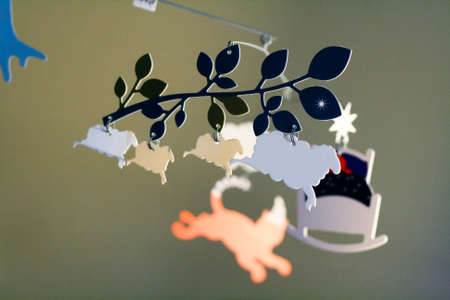 Child mobile of cardboard. Wood, house, watches, sheep, cat, cot, fox, mushrooms, month, stars, lights, owls.の写真素材