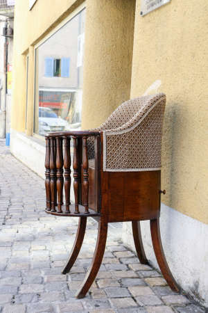 Vintage wooden Baby chair with upholstery on the street in the summer.の写真素材