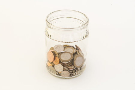Transparent bank with coins of different metals of different denominations from different countries