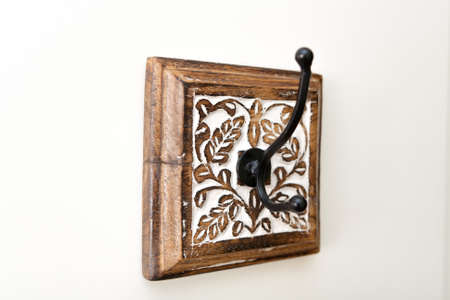 A hook with a wooden base with a thread in the form of leaves, painted white.の写真素材