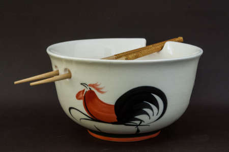 Deep white ceramic bowl with holes for sticks and drawingsの写真素材