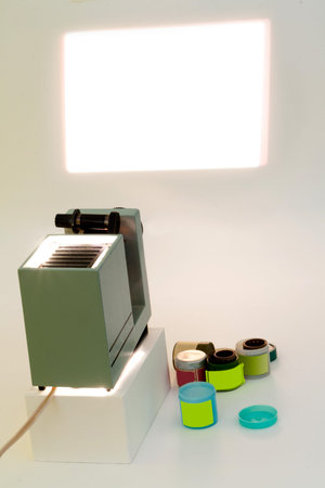 Old slide projector, reels with films and screen.