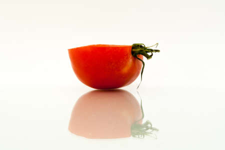 Half red tomato with reflection on white backgroundの写真素材