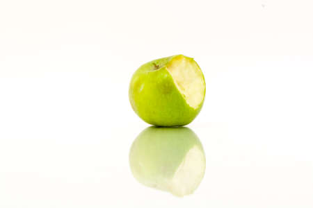 Bitten green apple with reflection on a white backgroundの写真素材