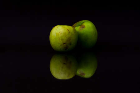 Green apple with reflection on black background.の写真素材