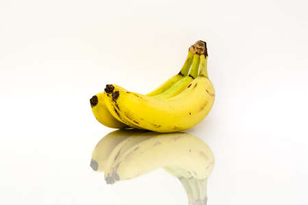 Yellow ripe bananas with reflection on white background.の写真素材