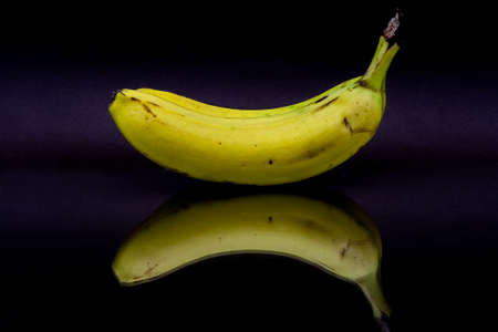 Yellow ripe bananas with reflection on black background.の写真素材
