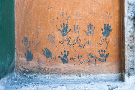 Prints of children's hands on the orange wall.の写真素材