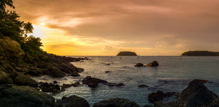 Sunset panoramic sea view on Kata beach. Phuket, Thailand. Stand Up Paddling on horizon.の写真素材