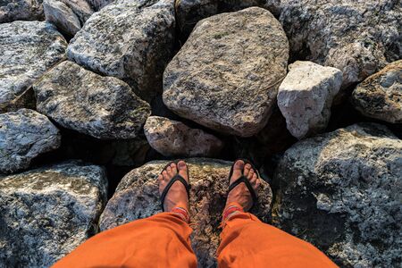 Man's legs on stones. Top view.の写真素材