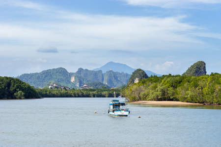 Landscape of a local boat in Khao Khanab Nam river water with beautiful mountains on background in...