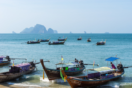 Ao Nang, Krabi Province, Thailand - January 21, 2019: Many thai local long-tail authentic boats floats near the shore in the azure sea water and wait for passengersのeditorial素材