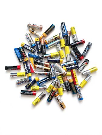 Moscow, Russia - April 19, 2019: Different brands of colorful batteries on white isolate background, Energy source for portable technology in AA size. View directly aboveのeditorial素材