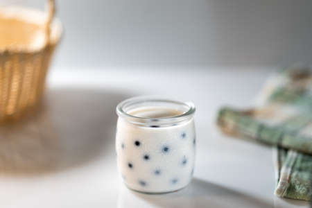 Fresh cold homemade milk yogurt in jar with berries in the morning light. Space for copy and textの写真素材