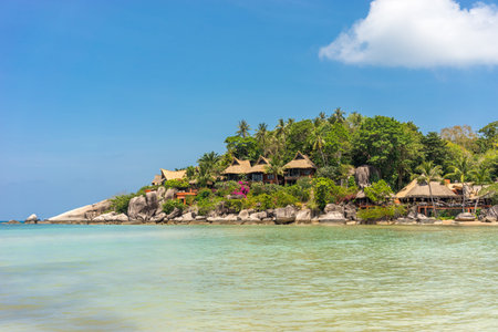 Picturesque seascape with resort on shore in lush greenery and rocks. Calm sunny sandy tropical place on exotic Koh Tao island in Thailandの写真素材