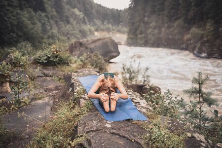 Woman sitting in yoga pose. The woman in the wood, meditation outdoors yoga mountain greenの写真素材