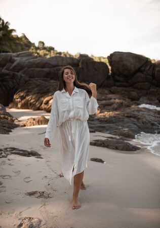 european young tan women have rest and run on white sand beach. long black chestnut hair . white cotton clothes. boho style dress.Thailand. Aquamarine crystal seaの写真素材