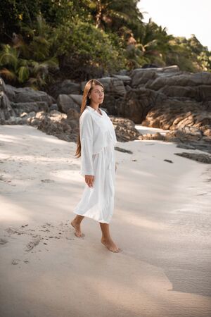 european young tan women have rest and run on white sand beach. long black chestnut hair . white cotton clothes. boho style dress.Thailand. Aquamarine crystal seaの写真素材