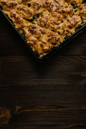 Meat cheese pizza. Baked meat in the oven lies on a black metal baking sheet. mouth-watering cheese sauce.の写真素材