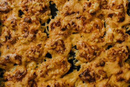 Meat cheese pizza. Baked meat in the oven lies on a black metal baking sheet. mouth-watering cheese sauce.の写真素材
