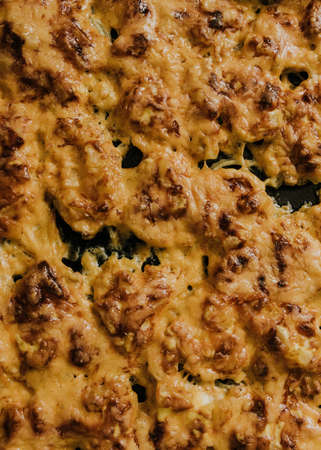 Meat cheese pizza. Baked meat in the oven lies on a black metal baking sheet. mouth-watering cheese sauce.の写真素材