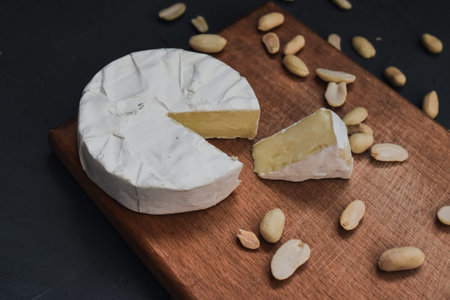 cheese camembert with mold and nuts on the wooden cutting board