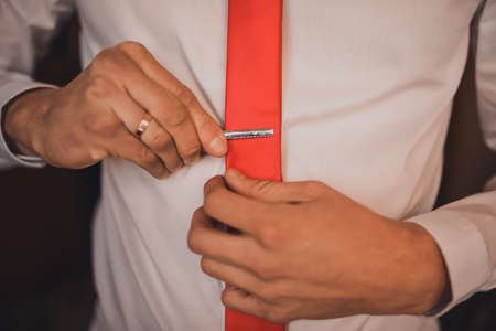 A man in a white shirt straightens his bow-tieの写真素材