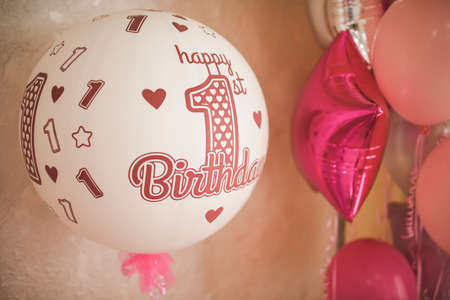White-pink air helium balloons in honor of the child birthday. decoration of a children party for a girlの写真素材