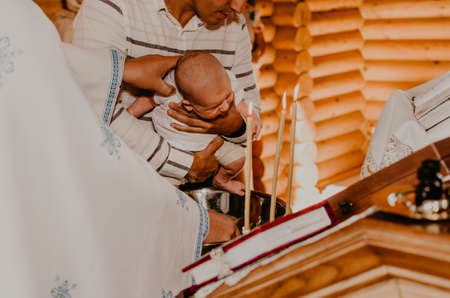 rite of sacrament of epiphany baby in church. priest washes child with Sacred water.の写真素材