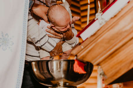 rite of sacrament of epiphany baby in church. priest washes child with Sacred water.の写真素材