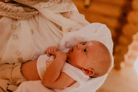 rite sacrament of epiphany child baby in church. A mother is holding a newborn child in her arms.の写真素材