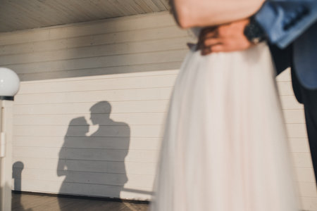 Shadow of a couple of newlyweds in love on a white wooden striped background.の写真素材