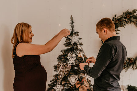 family with pregnant wife decorates the house for the New Year. Christmas morning. interior. Valentine's day celebrationの写真素材