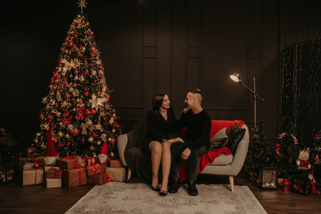 love couple man and woman hugging kissing near Christmas tree. decorated house for New Year. Christmas morning. apartment interior. Valentine's day celebrationの写真素材