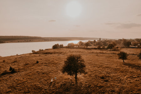 couple in love man and woman are walking along vast deserted meadow on grass in summer hot warm...