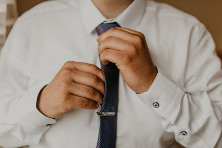 blonde European Caucasian young groom in shirt business suit with tie prepare for wedding. a man preparing for an important event a meeting indoors worriesの写真素材