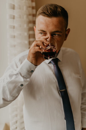 blonde European Caucasian young groom in shirt business suit with tie prepare for wedding. preparing...
