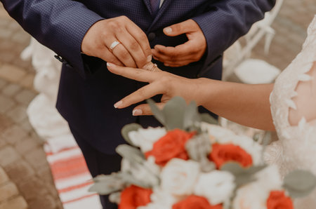 bride and groom exchange rings. a man puts a ring on woman ring finger as a sign of his love at a wedding. Slavic Ukrainian Russian traditionsの写真素材