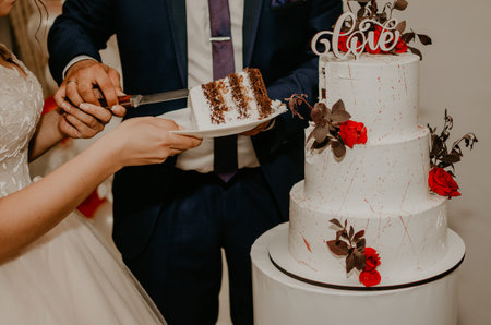 groom and bride at wedding cut their large multi-tiered white cake taste it fed from each other. Slavic Ukrainian Russian traditionsの写真素材
