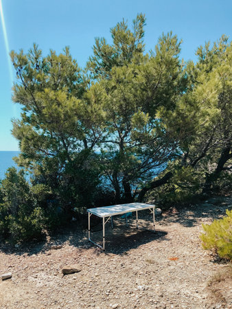 portable chair and table outdoors in summer. Nature, mountains and river, sun. Tourism and active...