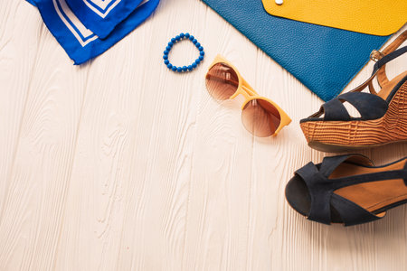 Sunglasses bijouterie jewelry bracelets clutch bag wedges shoes. Summer background mockup. top view above white wooden background Summer fashion accessories beach. Women summer design Vacation conceptの写真素材