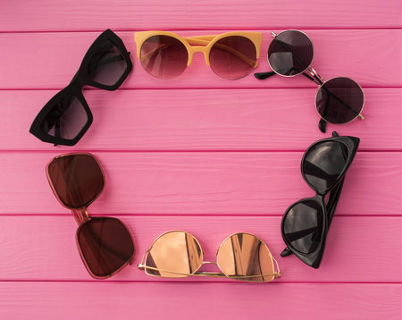 Summer abstract background mockup template free copy space for text pattern sample top view above on pink wooden board. blank empty area for inscription. sunglasses fashionable folded in circleの写真素材
