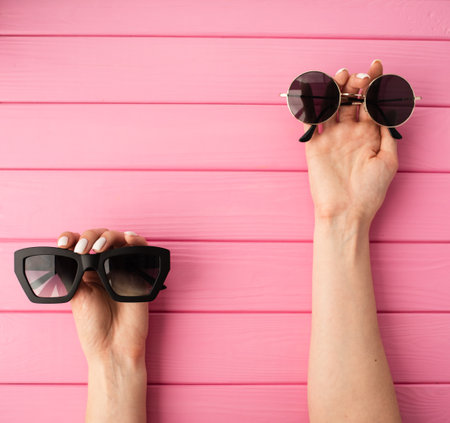 Summer abstract background mockup template free copy space for text pattern sample top view above on pink wooden board. blank empty area for inscription woman hands hold Couple sunglasses fashionableの写真素材