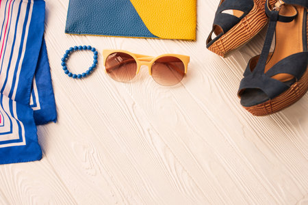 Sunglasses bijouterie jewelry bracelets clutch bag wedges shoes. Summer background mockup. top view above white wooden background Summer fashion accessories beach. Women summer design Vacation conceptの写真素材