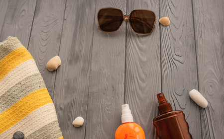 beachwear bag sun protection sunglasses sunscreen spray lotion cream care tan ultra-violet rays. Summer background template mockup free space pattern composition text. Top view above wooden backgroundの写真素材