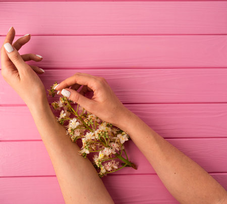 Summer abstract background mockup template free copy space for text pattern sample top view above pink wooden board. blank empty area for inscription woman hand manicure hold blossom flowers chestnutの写真素材