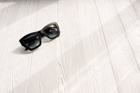 Stylish black sunglasses. Summer background mockup template text. pattern top view above white wooden background. Summer fashion accessories for beach. Women design sunglasses. Vacation conceptの写真素材