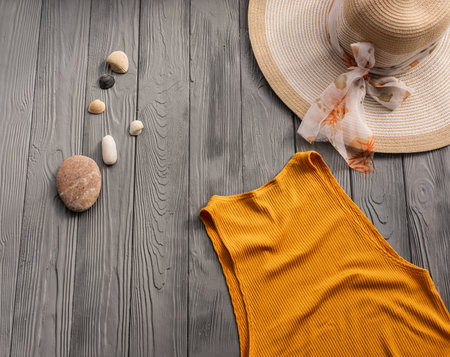 beachwear orange woman top outfit hat bag sun protection sunglasses pebbles. Summer background template mockup free space composition sample text. Top view above wooden background vacation conceptの写真素材