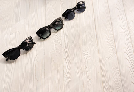 Stylish black sunglasses. Summer background mockup template text. pattern top view above white wooden background. Summer fashion accessories for beach. Women summer design sunglasses. Vacation conceptの写真素材