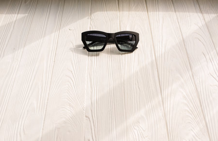 Stylish black sunglasses. Summer background mockup template text. pattern top view above white wooden background. Summer fashion accessories for beach. Women design sunglasses. Vacation conceptの写真素材
